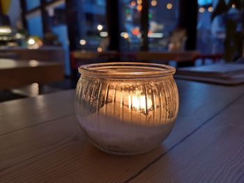 Close-up of illuminated candle on table