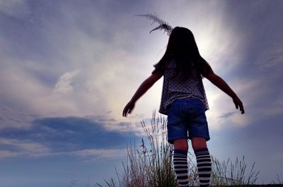 Rear view of woman standing against sky