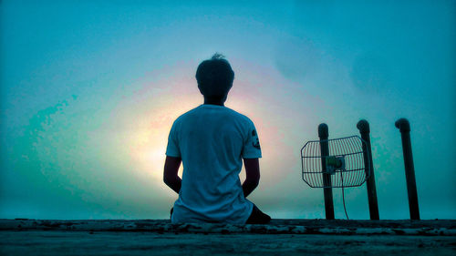 Rear view of man looking at sea against sky