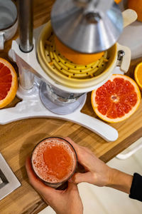 Cropped hand of woman holding juice in glass