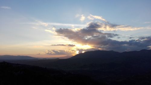 Scenic view of silhouette mountains against sky at sunset