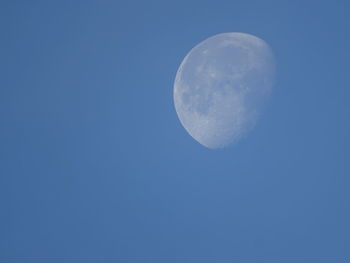 Low angle view of moon against blue sky at night