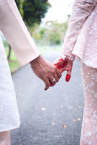 Closeup view of married couple holding hands.