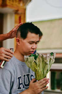 Man holding flower bouquet outdoors