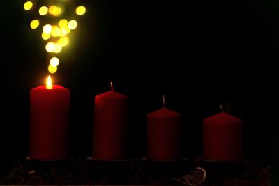 Close-up of illuminated candles against black background