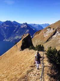 Rear view of woman on mountain against sky