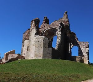 Low angle view of old ruins against blue sky