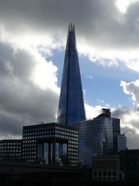 Low angle view of modern building against cloudy sky