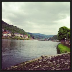 River in city against cloudy sky