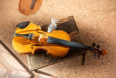 Violin with feather resting on stool