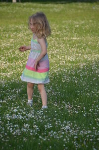 Portrait of girl standing on grassy field
