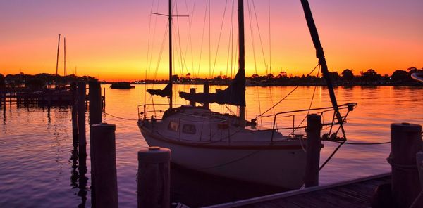 Boats in harbor at sunset