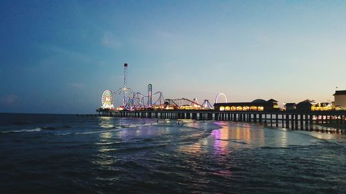 View of illuminated built structure by sea