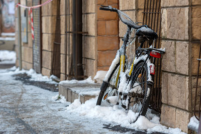 Bicycle on snow covered building in city