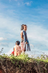 Rear view of girl and daughter against sky