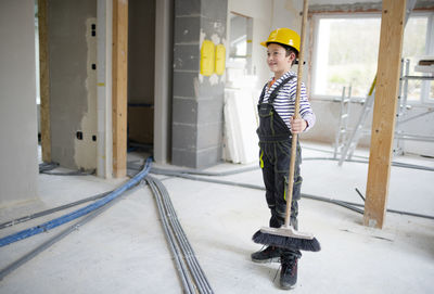 Side view of young man standing in factory