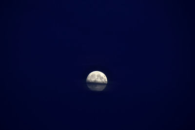 Low angle view of moon against clear blue sky