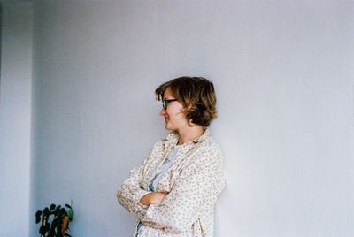 Woman looking away against wall