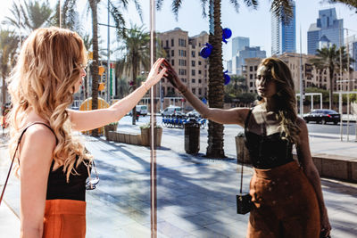 Young woman reflecting on window