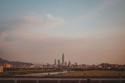 Buildings in city against cloudy sky