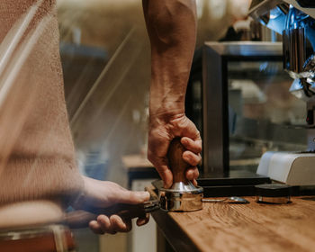 Cropped hand holding pota filter on table