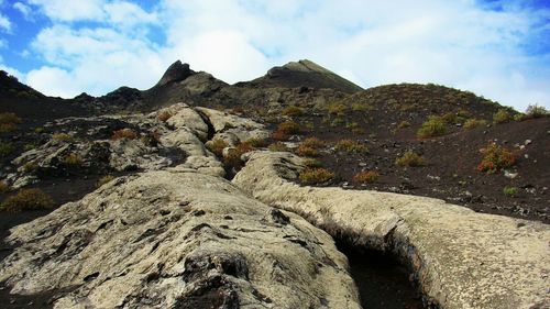 Scenic view of rock formations against cloudy sky