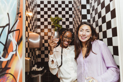 Portrait of female friends with wineglass in restaurant