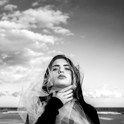 Portrait of beautiful young woman against sky