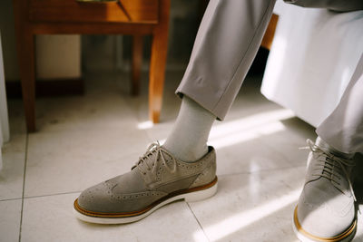 Low section of man standing on tiled floor