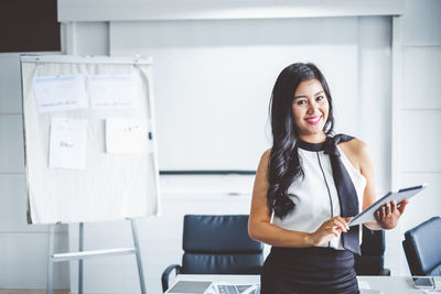 Portrait of smiling woman standing at home