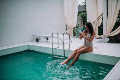 Woman jumping in swimming pool