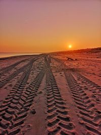 Scenic view of beach against clear sky during sunset