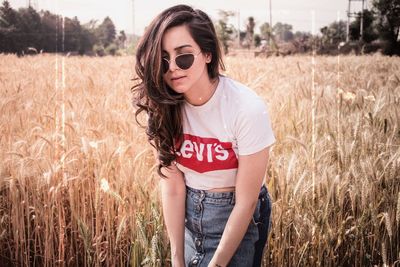 Beautiful young woman standing on field