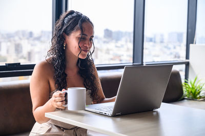 Young woman using laptop at table