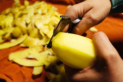 Cropped image hands peeling on potato