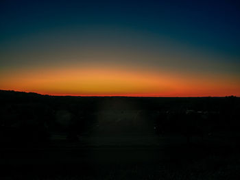 Scenic view of silhouette field against sky during sunset