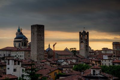 Buildings in city against cloudy sky