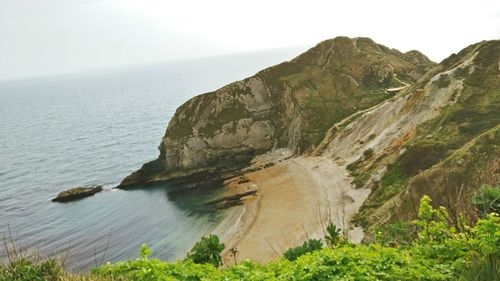 Scenic view of sea and mountains against sky