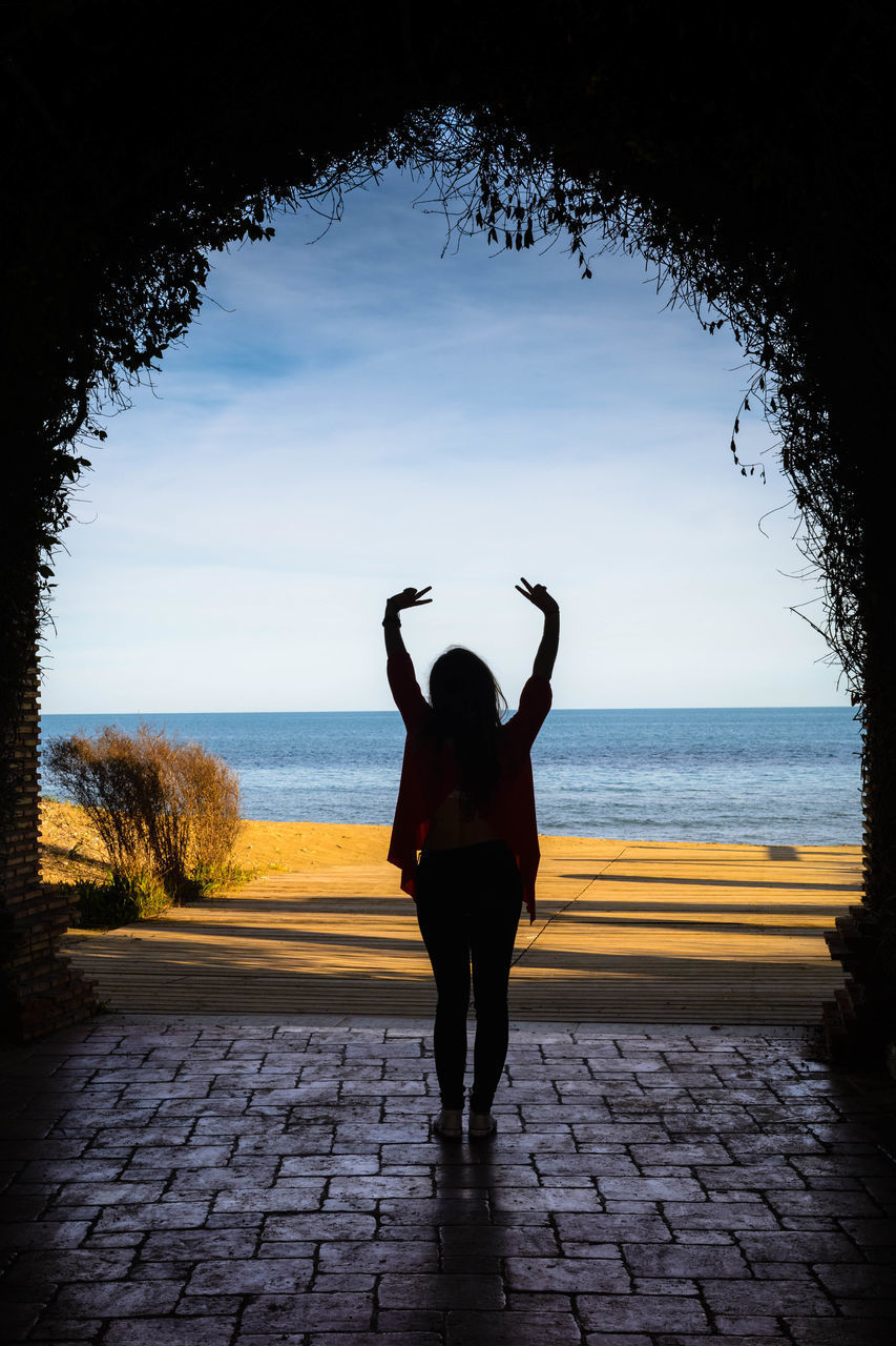 FULL LENGTH REAR VIEW OF SILHOUETTE WOMAN STANDING AT SEA SHORE