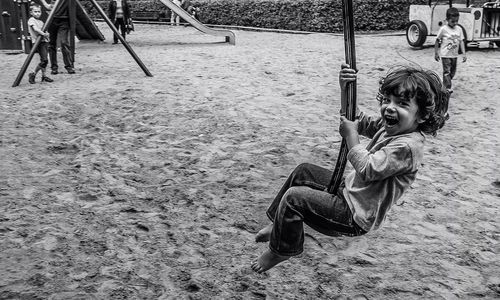 Portrait of happy girl swinging in playground