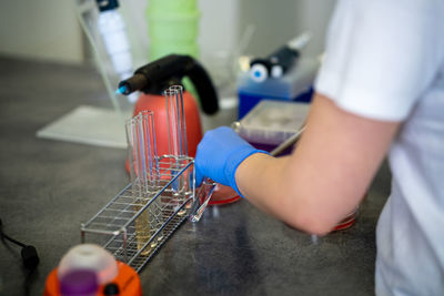 Midsection of scientist experimenting in laboratory