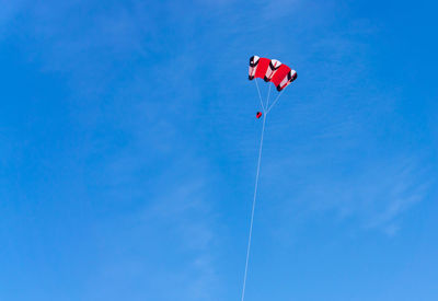 Low angle view of kite flying against blue sky