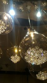 Low angle view of illuminated light bulb hanging from ceiling