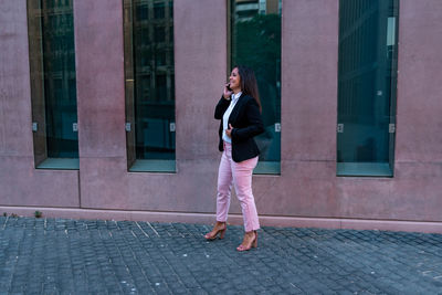 Full length of woman standing on footpath