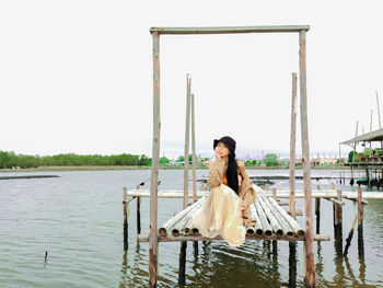 Woman sitting on a boat against clear sky