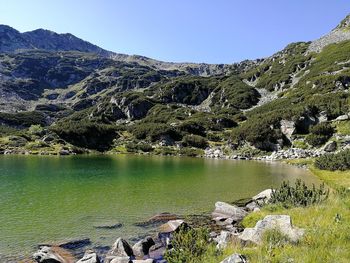Scenic view of lake and mountains against clear sky