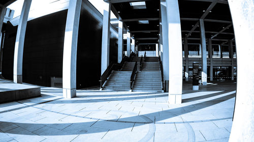 Empty footpath amidst buildings in city