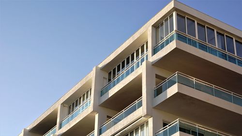 Low angle view of modern building against clear blue sky