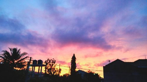 Silhouette of trees against dramatic sky