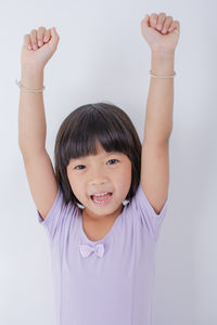 Portrait of boy holding toy against white background